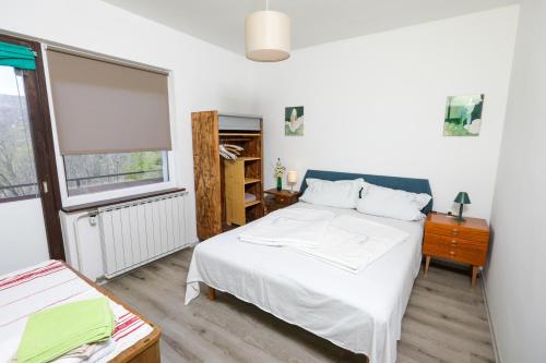 1 dormitorio con cama blanca y ventana en Apartment Karlo, en Radatovići