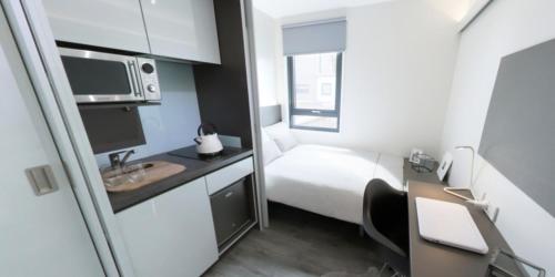 a small white room with a bed and a sink at Chapter Highbury I in London in London