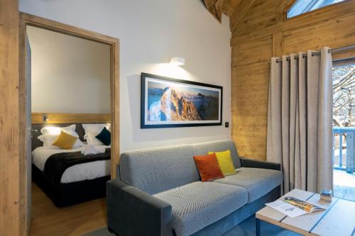 a room with a couch and a bed and a mirror at MGM Hôtels & Résidences - Résidence Chalets Elena in Les Houches