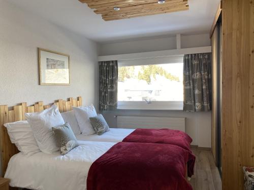 Schlafzimmer mit einem großen weißen Bett und einem Fenster in der Unterkunft Chez Chantal in Siviez