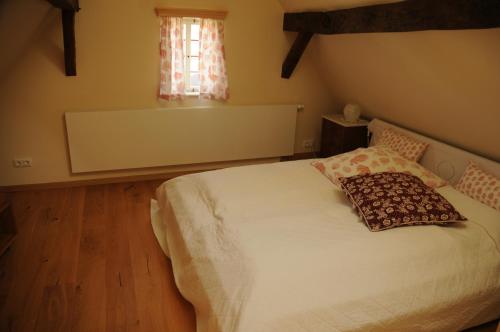 um quarto com uma cama branca e uma almofada em Fachwerkhaus em Rettert