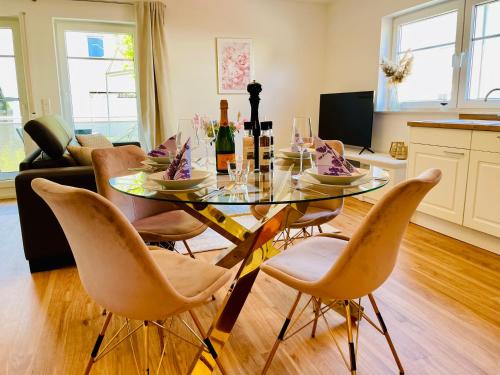 a dining room with a glass table and chairs at Ferien-Apartment Silberweide - mit priv Strandzugang in Friedrichshafen