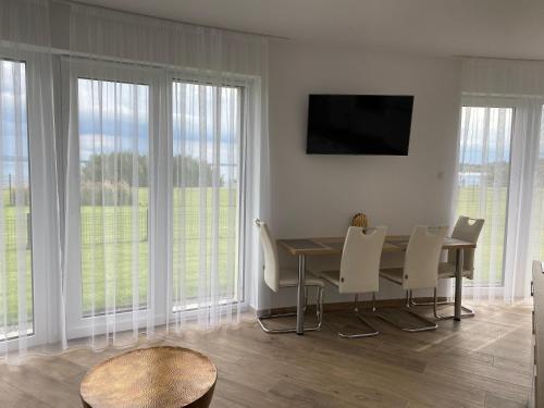 凱斯特海伊的住宿－ROYAL SUN - lakeside luxury studio flat at Balaton，一间带桌椅和窗户的用餐室