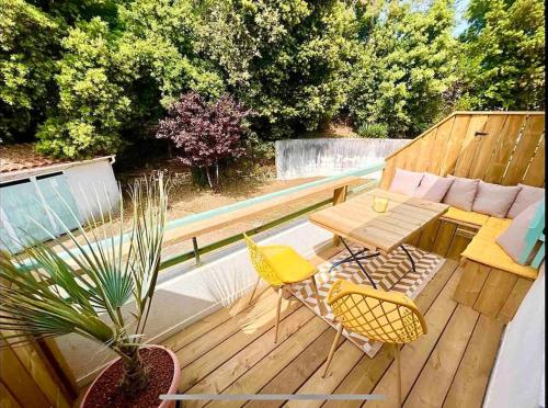 Una terraza de madera con una mesa y sillas. en Front de mer Rivedoux-Plage - Terrasse Extérieur - Parking, en Rivedoux-Plage