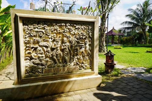 a wall with a relief on it next to a fire hydrant at Adil Villa & Resort in Ubud