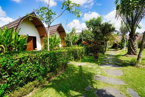 a house with a walkway next to a yard at Adil Villa & Resort in Ubud