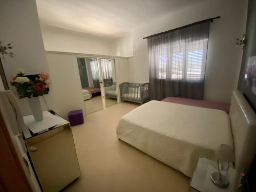 1 dormitorio con 1 cama y 1 habitación con sofá en Sabea Guest House, en Melissano