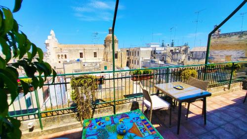 a balcony with a table and chairs and a view of a city at Attico Barocco in Lecce