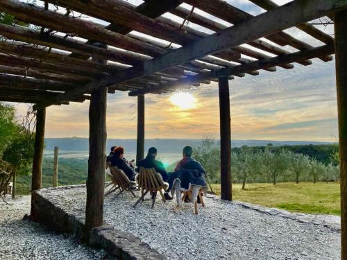 a group of people sitting on chairs under a pergola at Pousada Olival Vila do Segredo in Caçapava do Sul