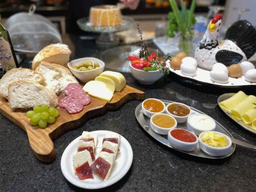 a table topped with different types of food on plates at Pousada Olival Vila do Segredo in Caçapava do Sul