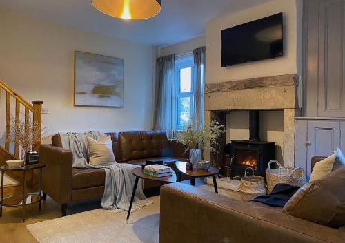 a living room with a couch and a fireplace at Beautiful & cosy 4 bedroom home in Todmorden