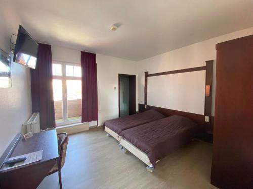 a bedroom with a bed and a desk and a television at Vakantiecentrum Zeelinde in De Haan