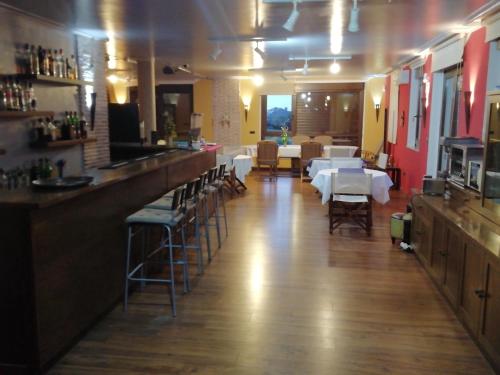 a restaurant with a bar with white tables and chairs at Casa Buda Conors & Spa in Foz