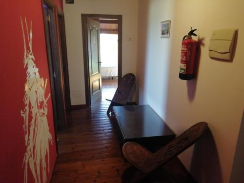 a room with a table and a fire extinguisher on the wall at Casa Buda Conors & Spa in Foz