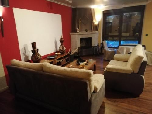 a living room with two couches and a fireplace at Casa Buda Conors & Spa in Foz