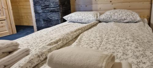 a bed with two pillows on top of it at Leśniczówka Kalina in Wetlina