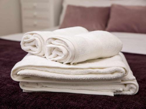 a pile of towels sitting on top of a bed at A Casiña Casa Rural en Galicia in Ourense