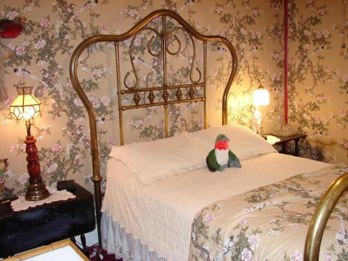 a stuffed parrot sitting on a bed in a bedroom at Bisbee Grand Hotel in Bisbee