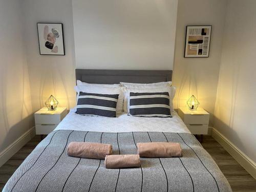 a bedroom with a large bed with two pillows at Modern Ground Floor Garden Apartment With Parking in South Hayling