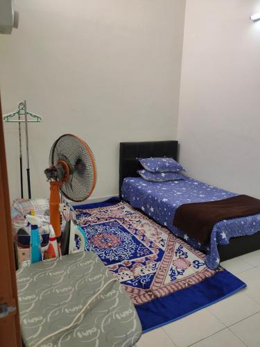 a bedroom with a bed and a fan at Homestay Intan Payung Bukit Katil Tuah Perdana in Malacca