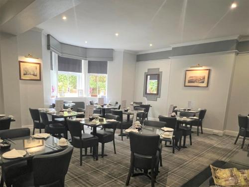 a restaurant with tables and chairs in a room at Mansion House in Scarborough