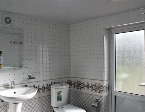 a bathroom with a toilet and a sink at Spring Family Guest House in Tersak