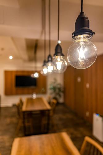 a dining room with a table and lights at ETAVIA Yufuin Kinrinko in Yufuin