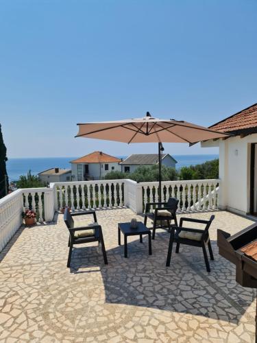 a patio with chairs and an umbrella and a fence at Luxury Penthouse with panoramic view in Ulcinj