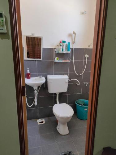 a bathroom with a toilet and a sink at Homestay Intan Payung Bukit Katil Tuah Perdana in Malacca