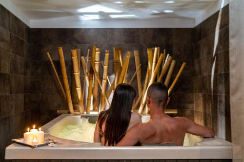 a man and a woman sitting in a bath tub at Hotel Europa Lignano in Lignano Sabbiadoro