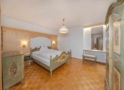 Schlafzimmer mit einem Bett, einem Tisch und einem Spiegel in der Unterkunft Gabriel in St. Ulrich in Gröden