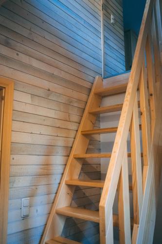 a wooden staircase in a house with wooden walls at Casa de Vacanta Colibita Veche- pe malul lacului in Colibiţa