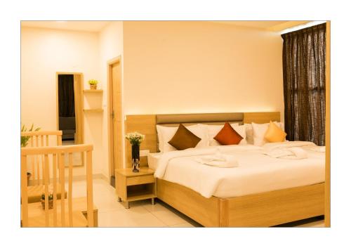 a bedroom with a large bed with white sheets at Hotel Ashoka in Rāmeswaram