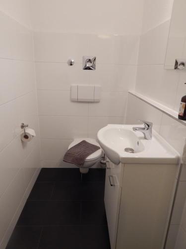 a white bathroom with a sink and a toilet at FREE Apartment - Obere Wässere in Reutlingen