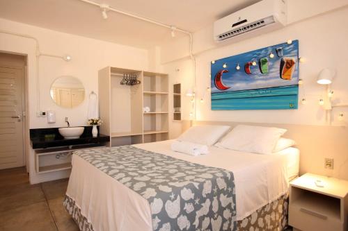 a bedroom with a bed and a bathroom with a sink at Saint Germain Kite Residence in Icaraí