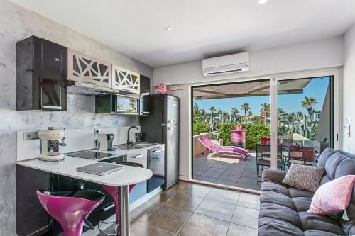 une cuisine et un salon avec un canapé dans l'établissement Palmeraie beach Heliopolis Naturiste, au Cap d'Agde