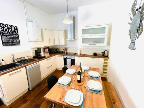 a kitchen with a wooden table with plates on it at Lottie's Lookout, Ventnor with fantastic Sea Views in Ventnor