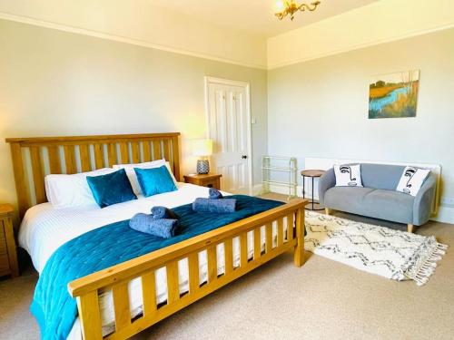 1 dormitorio con 1 cama grande de madera y 1 silla en Lottie's Lookout, Ventnor with fantastic Sea Views, en Ventnor