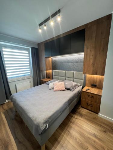 um quarto com uma cama grande e piso em madeira em Tricity Apartments - Wilga Park em Gdansk