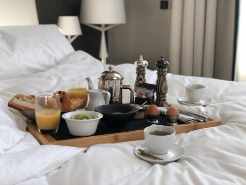 a tray with breakfast foods and drinks on a bed at InterContinental Marseille - Hotel Dieu by IHG in Marseille