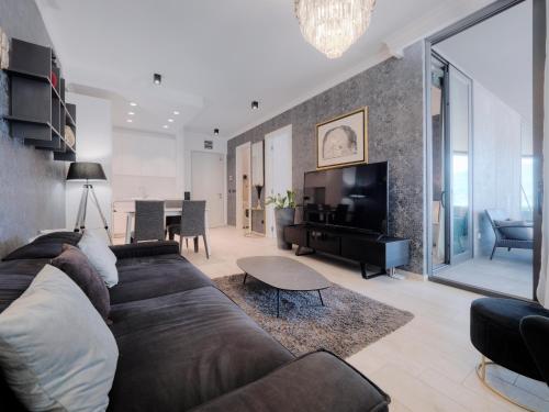 a living room with a large couch and a television at Royal Montesun Apartments in Budva