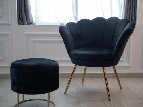 a blue chair and a stool in a room at Royal Montesun Apartments in Budva