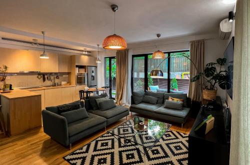 ein Wohnzimmer mit 2 Sofas und einer Küche in der Unterkunft GREEN CORNER Apartment in Bukarest