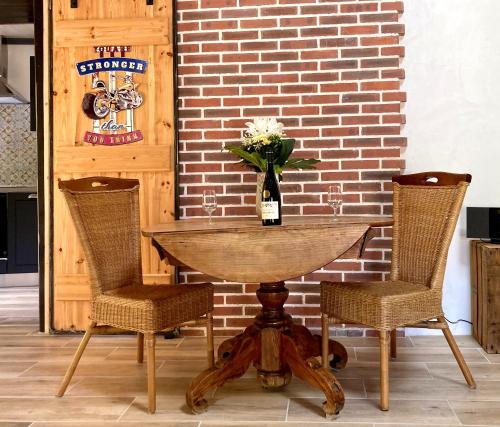 - une table avec 2 chaises et une bouteille de vin dans l'établissement Mont2roux, à Montpeyroux
