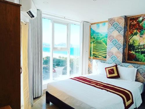 a bedroom with a bed and a large window at VANDA Hotel Nha Trang in Nha Trang