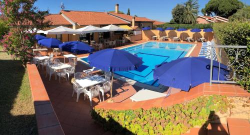 a swimming pool with umbrellas and tables and chairs at Residence Alithai in Portoferraio