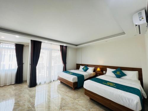 Cette chambre comprend 2 lits et 2 fenêtres. dans l'établissement Sunrise Motel, à Hạ Long