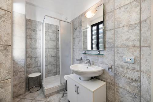 a white bathroom with a sink and a shower at 18 Mehari in Varigotti