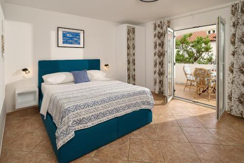 a bedroom with a blue bed and a balcony at Holiday Park Mandrice in Mandre