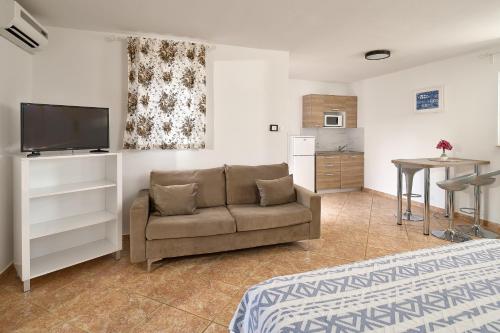 a living room with a couch and a kitchen at Holiday Park Mandrice in Mandre